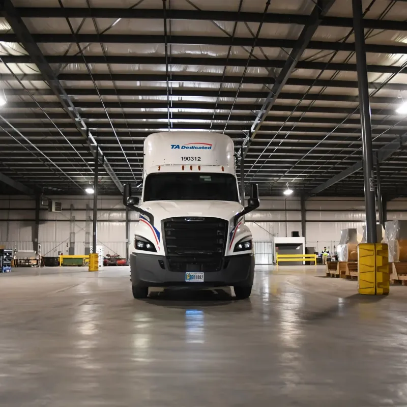 Front view of TA Dedicated truck leaving warehouse