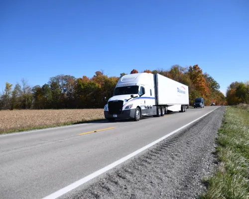 Dedicated logistics semi-truck transporting freight on rural highway